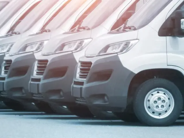 A long row of white passenger vans.